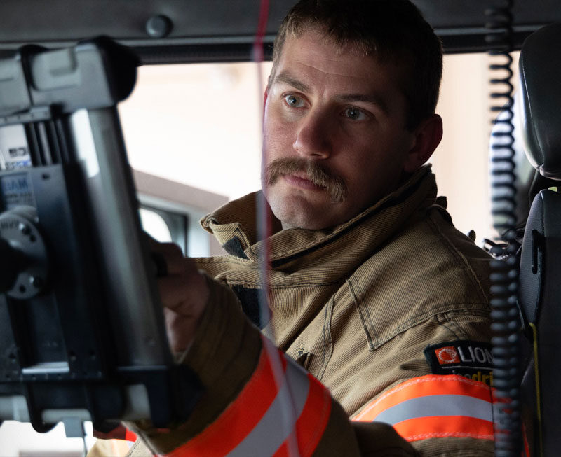 First responder engages with technology on tablet in his apparatus